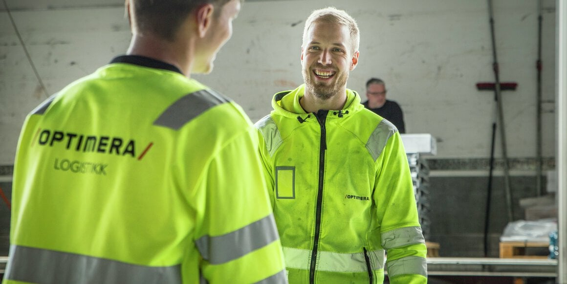 To ansatte i Optimera Logistikk som er i ferd med å bære ut kunder fra lageret.