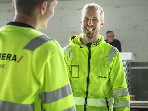 ansatte i Optimera Logistikk bærer byggevarer fra lageret til kjøretøy for utkjøring til kunde.